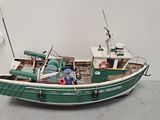 a model of a green and white boat sitting on the floor