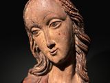 statue of a woman with long hair and braids in a dark room
