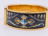 gold plated bracelet with blue and yellow enamel design on it