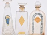 trois flacons de parfum sont alignés les uns à côté des autres sur une surface blanche