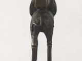 a bronze statue of a man with a cone on his head