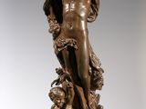 bronze statue of a woman holding a ball on a pedestal
