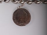 a silver chain with a coin attached to it