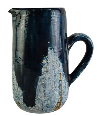 a blue and black pitcher that is sitting on a table