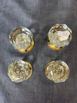 four glass vases with gold rims sitting on a gray cloth