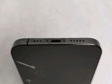 the back of a black cell phone sitting on top of a white table
