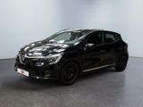 La voiture noire est garée dans une pièce blanche au sol noir.