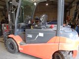 a forklift in a warehouse with a door open