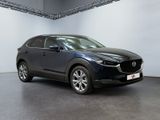 a black mazda cx - hr suv parked in a showroom