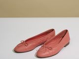 une paire de chaussures roses posée sur une table blanche