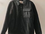 the jacket is hanging on a hanger on the wall