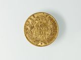 gros plan d'une pièce d'or sur une surface blanche