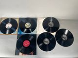 four black vinyl records sitting on top of a white table