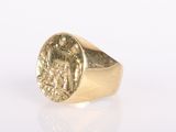 a close up of a gold ring with a coin on it