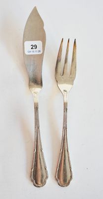 deux fourchettes et un couteau sur une table blanche
