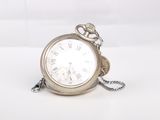 a silver pocket watch with a chain around it