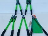 four green and black garden tools sitting on top of a white surface