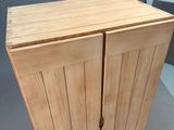 a wooden cabinet with two doors open on a table
