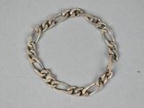a close up of a silver bracelet on a white surface