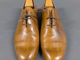 a close up of a pair of brown shoes on a gray surface