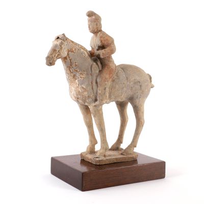 statue d'un homme à cheval sur un socle en bois