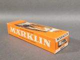 an orange box of markin cigarettes sitting on a gray surface