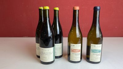quatre bouteilles de vin sont alignées sur une table