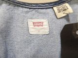 a close up of a blue shirt with a tag on it