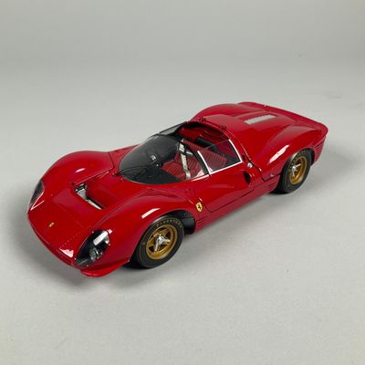 the toy car is red and has gold rims on it