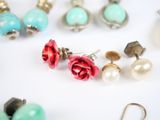 many pairs of earrings that are laying on a table
