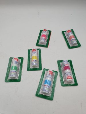 six tubes de dentifrice posés sur une table blanche