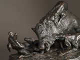 a bronze sculpture of a boar and two baby boars on a rock