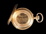a close up of a gold pocket watch on a black background