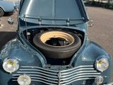 an old car with a tire in the trunk