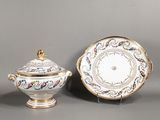 Deux assiettes en porcelaine et une soucoupe sont posées sur une table.
