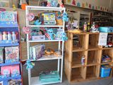 a woman standing in front of a store filled with toys