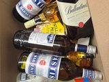 many bottles of alcohol in a cardboard box on the floor