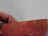 a person holding a knife cutting a tomato in half