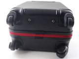 a black suitcase with a red handle on a white surface