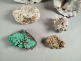 several pieces of green and brown rocks on a white surface