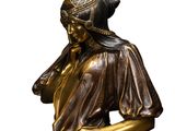 bronze statue of a woman with a hat on her head and a scarf around her neck