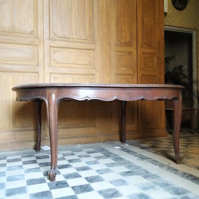 une grande table en bois dans une pièce au sol carrelé