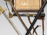two swords and a plaque on display in a wooden case