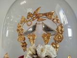 a cake in a glass dome with gold decorations on it