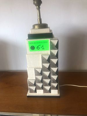 une lampe posée sur une table sur laquelle se trouve une horloge