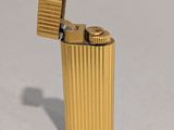 l'image d'un briquet doré posé sur une surface blanche