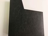 a close up of a piece of black paper on a white surface