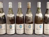six bouteilles de vin sont alignées sur une table