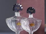 two bottles of perfume sitting on a table next to a box