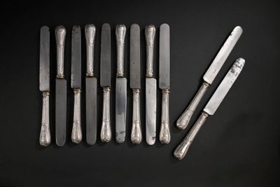 beaucoup de couverts sur une table où se trouve un couteau